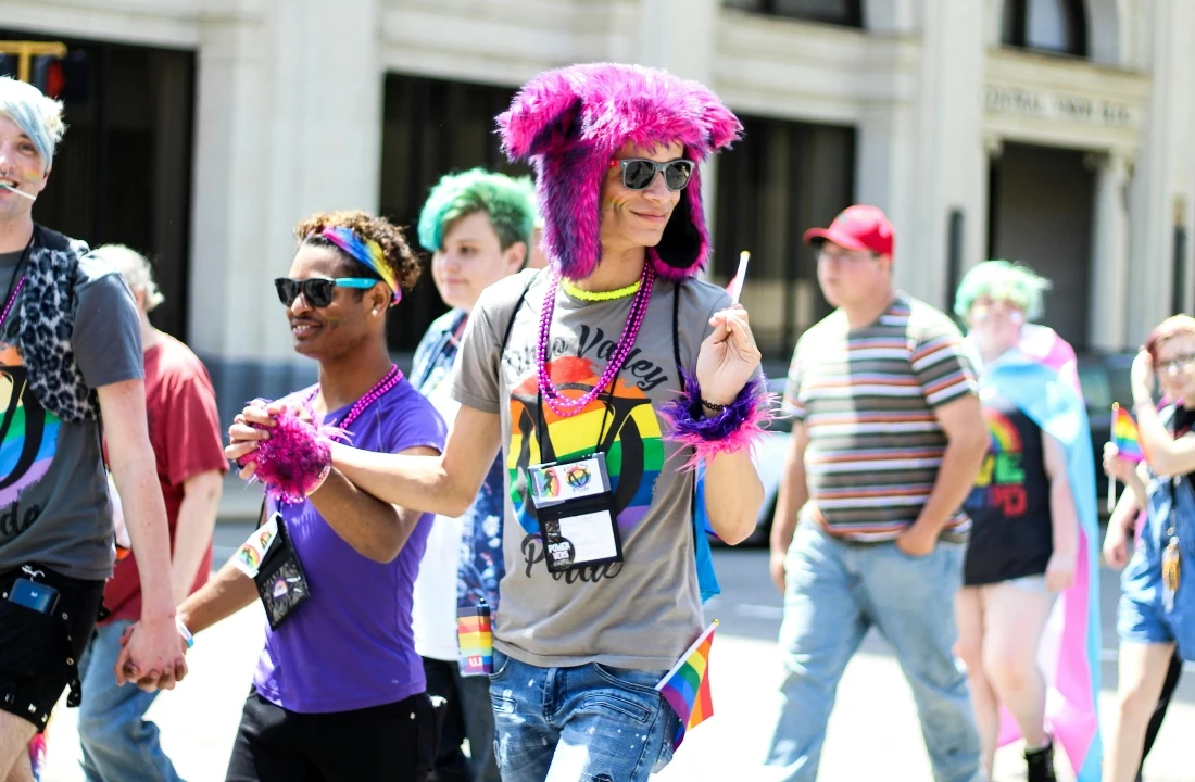 People wearing colorful pride shirts at an outdoor community event, suitable for pride merch, pride apparel, and custom event shirts