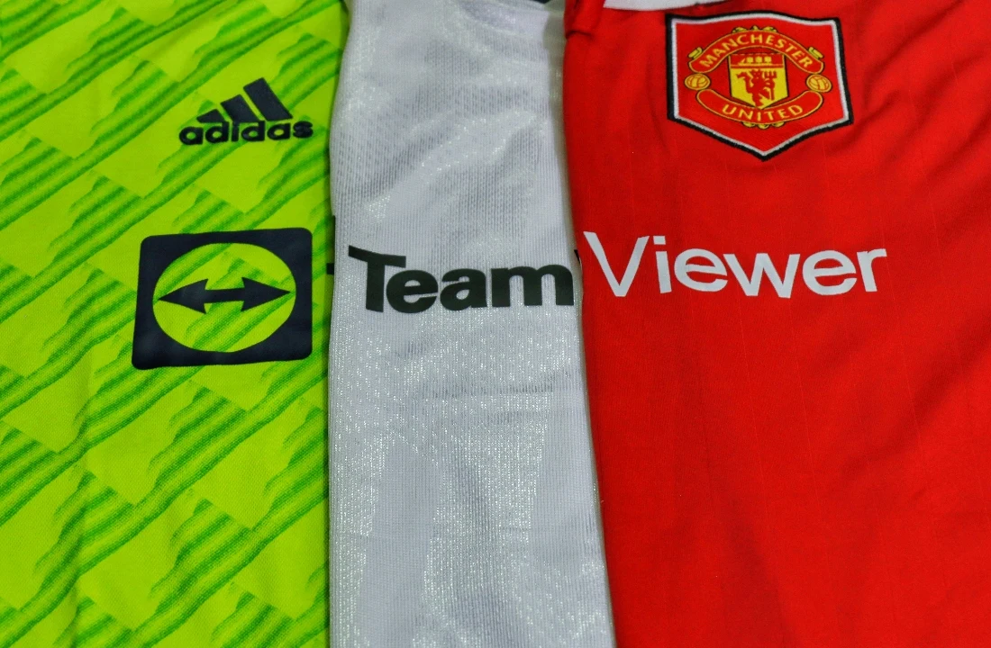 Custom Football Shirts close-up image showing sports jersey fabric, color-blocked panels, crest placement, and logo details, suitable for discussing mesh fabric, sublimation, embroidery, and decoration quality