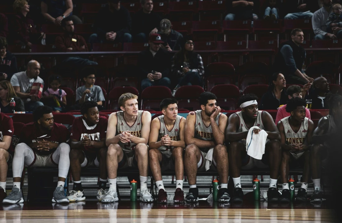 Fan Club Shirts image showing a basketball team huddle in matching uniforms, suitable for custom basketball jerseys, custom team jerseys, and organized sports team apparel