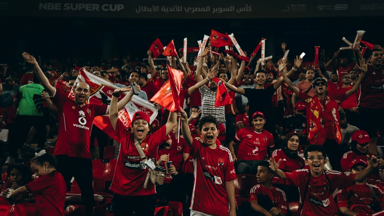 Fan Club Shirts image showing a large stadium supporter crowd in red shirts, suitable for basketball fan apparel, sports event shirts, and high-energy fan club campaigns