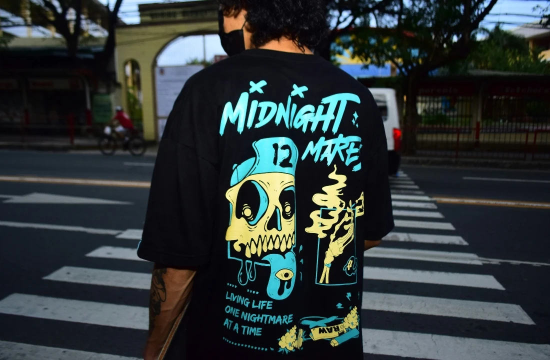 Print on Demand Streetwear image showing an oversized black back graphic tee on a city street, suitable for POD streetwear drops, bold artwork placement, and custom T shirt desig