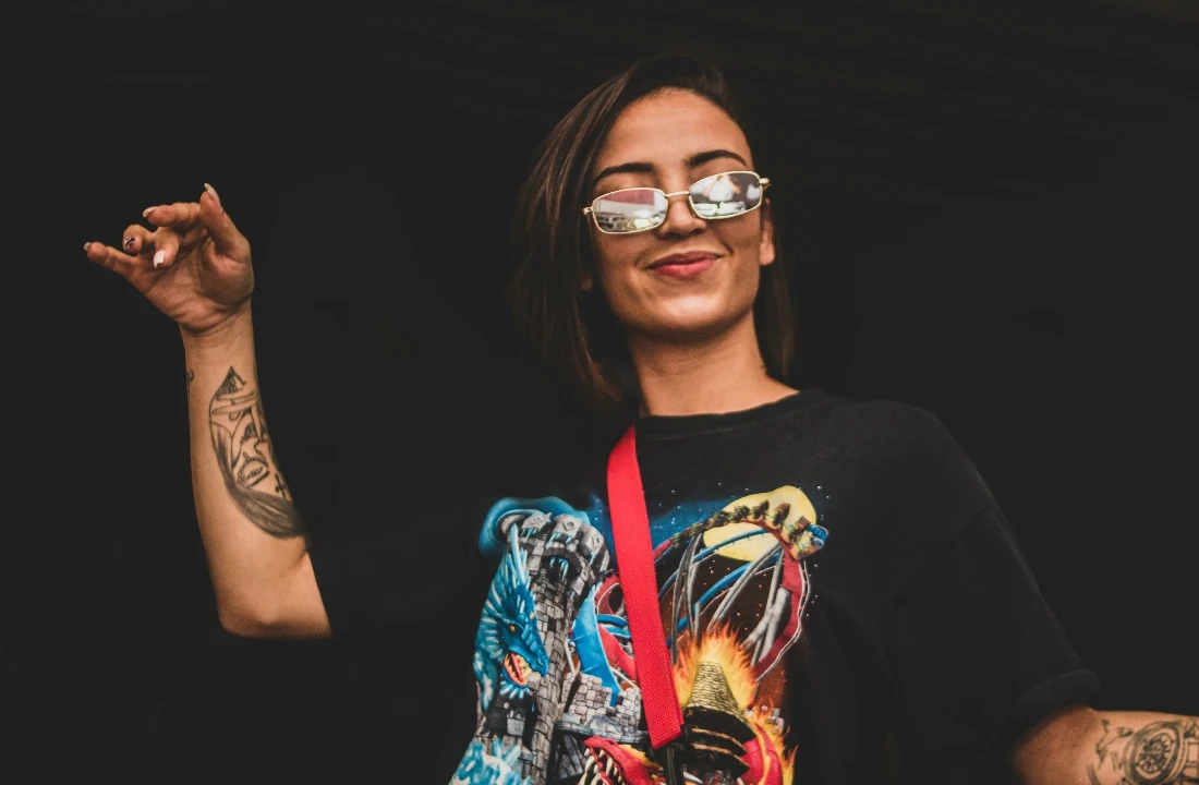 Woman wearing an oversized black fantasy graphic T-shirt and sunglasses, suitable for bold Print on Demand Streetwear artwork and fashion drops