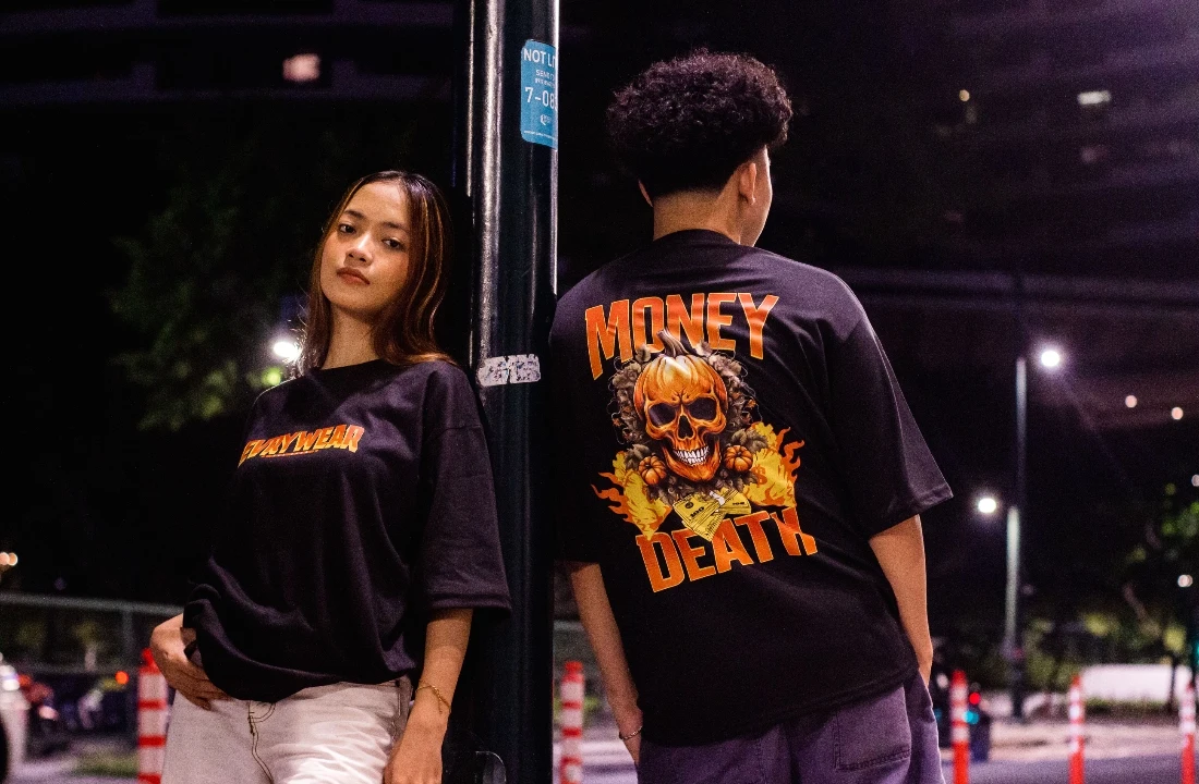 Two models wearing oversized black graphic T-shirts during a nighttime urban POD Streetwear photoshoot