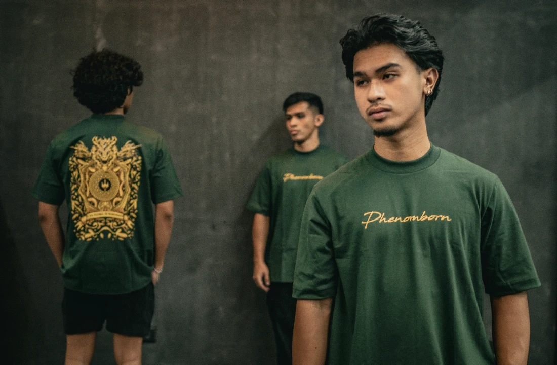 Three models wearing green print on demand streetwear T-shirts with front and back logo graphics