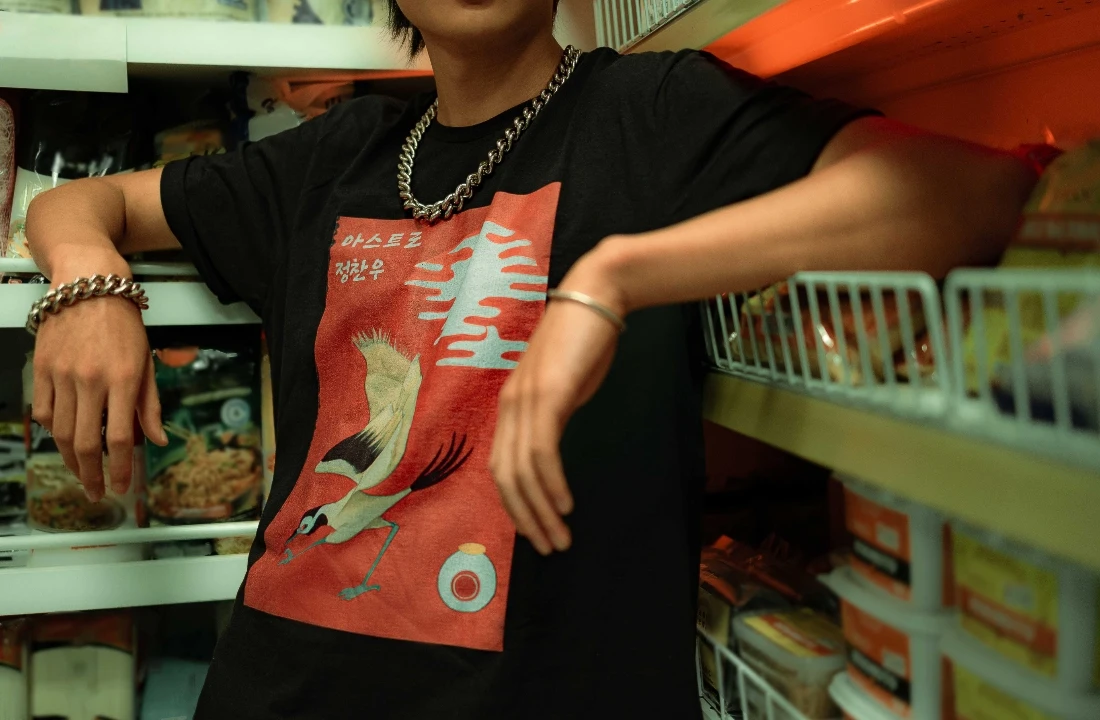 Close-up of a model wearing a black print on demand streetwear T-shirt with an artistic front graphic