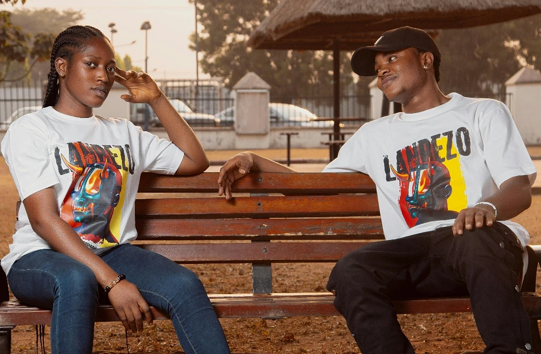 Two people sitting on a bench wearing matching Streetwear Print on Demand graphic T-shirts
