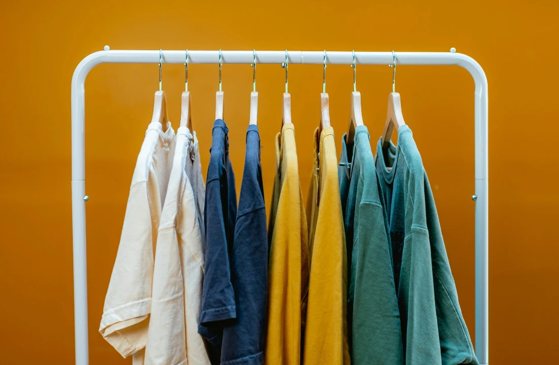 A rack of Heavyweight Cotton T Shirts in neutral, navy, yellow, and green colors for apparel collections