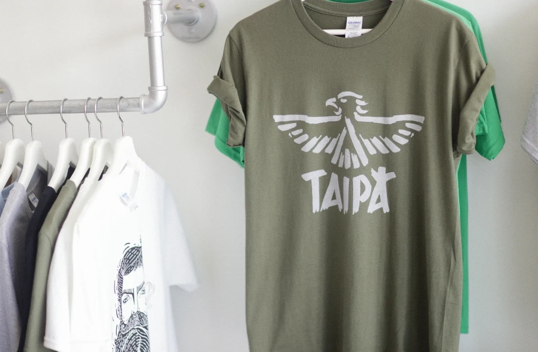 Retail display of Organic Cotton Custom T Shirts featuring an olive green printed tee and assorted blank shirts