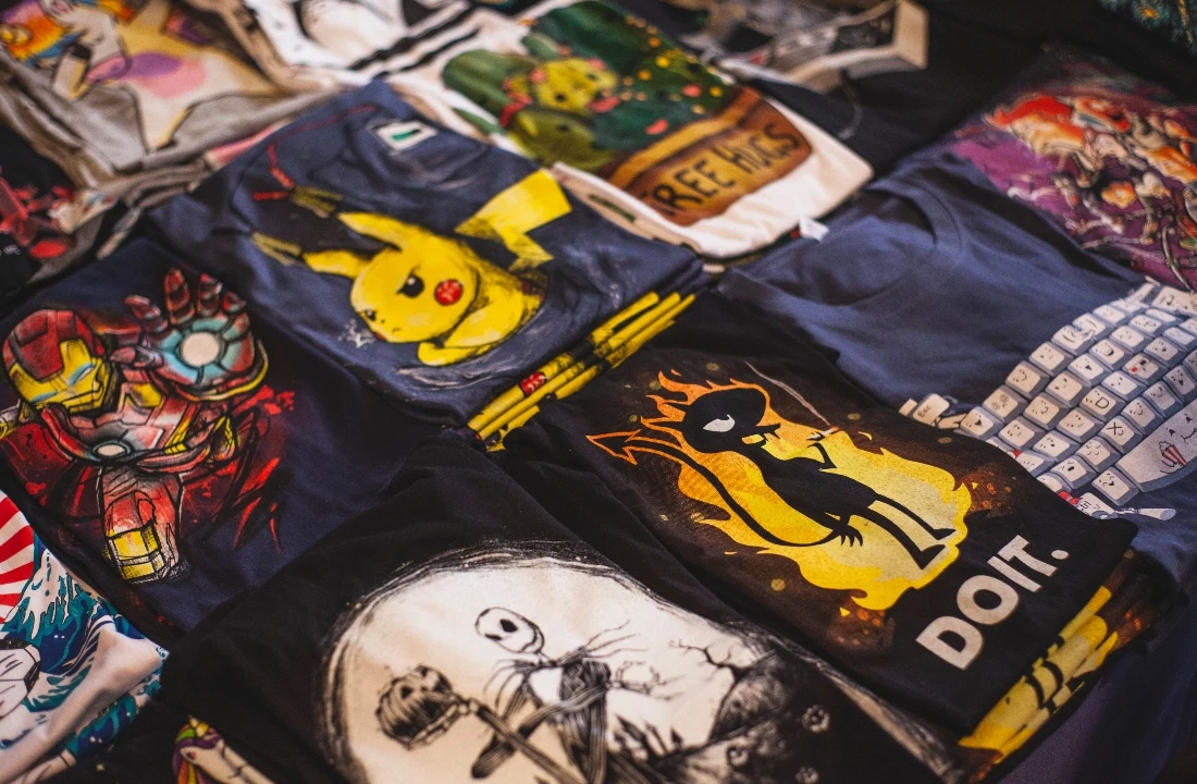 Folded washed t shirts with colorful graphic prints displayed together for streetwear collection inspiration