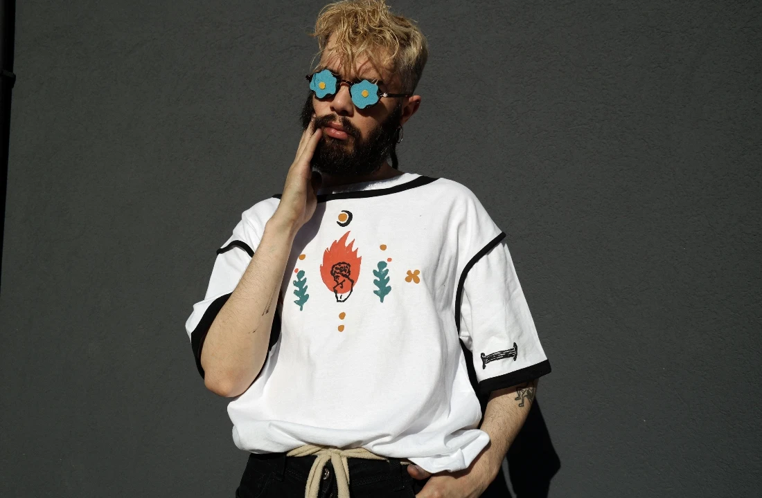 Model wearing boxy fit t shirts with contrast sleeve trim and a small front graphic in a streetwear outfit