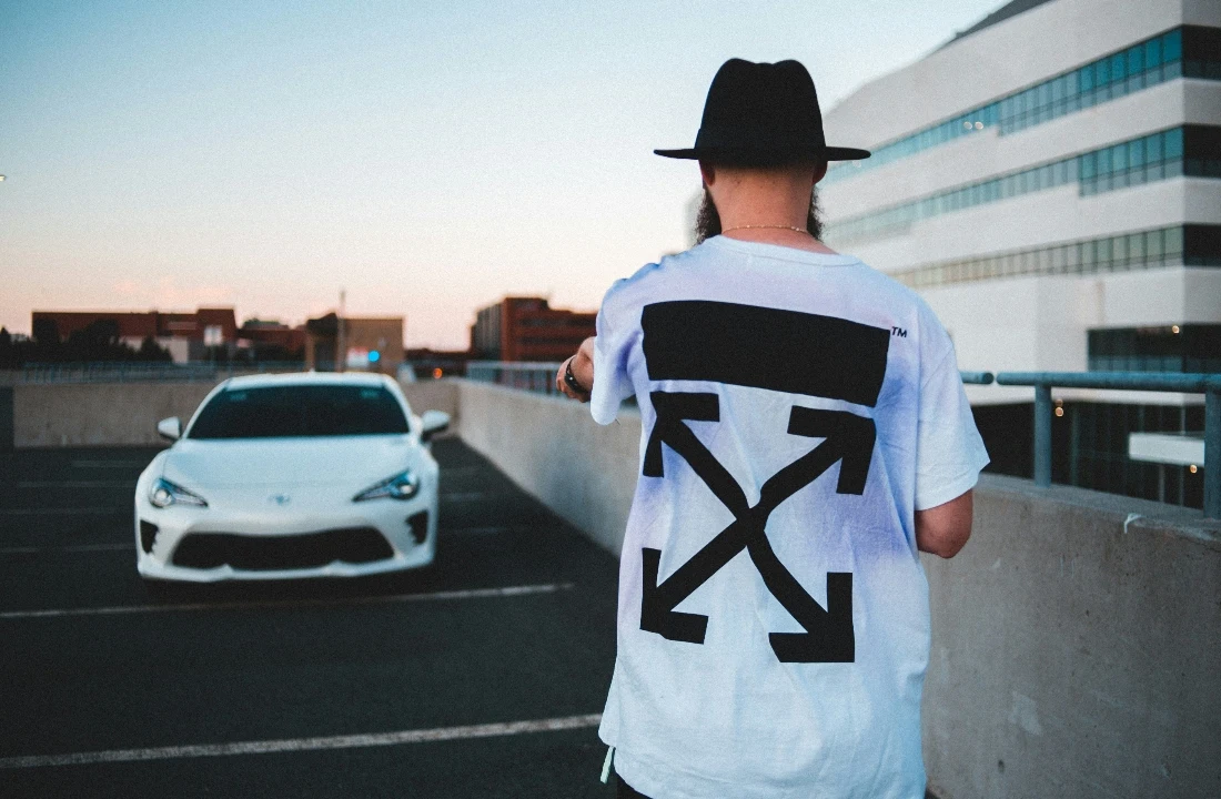Model wearing boxy fit t shirts with an oversized back graphic on a rooftop parking deck at sunset