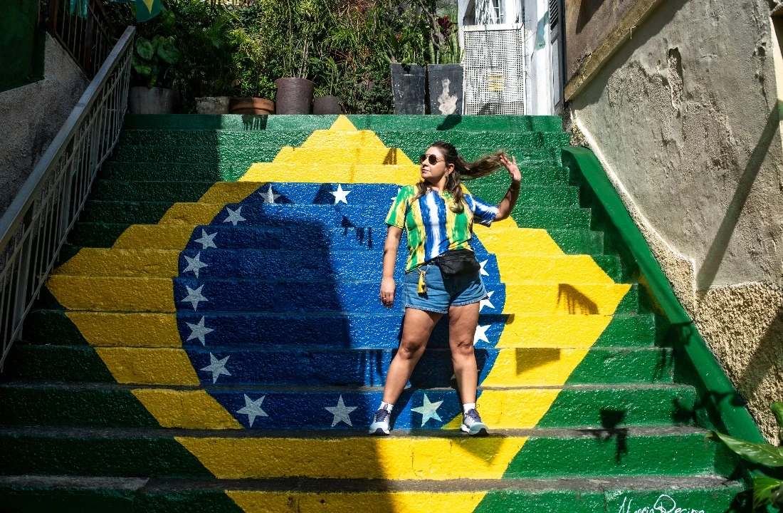 Woman wearing a custom football shirt near Brazil-themed painted stairs for fan campaign styling