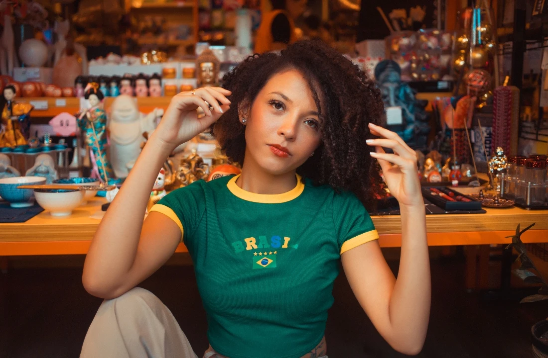Woman wearing a fitted green custom football shirt with Brazil-inspired details in a colorful indoor setting