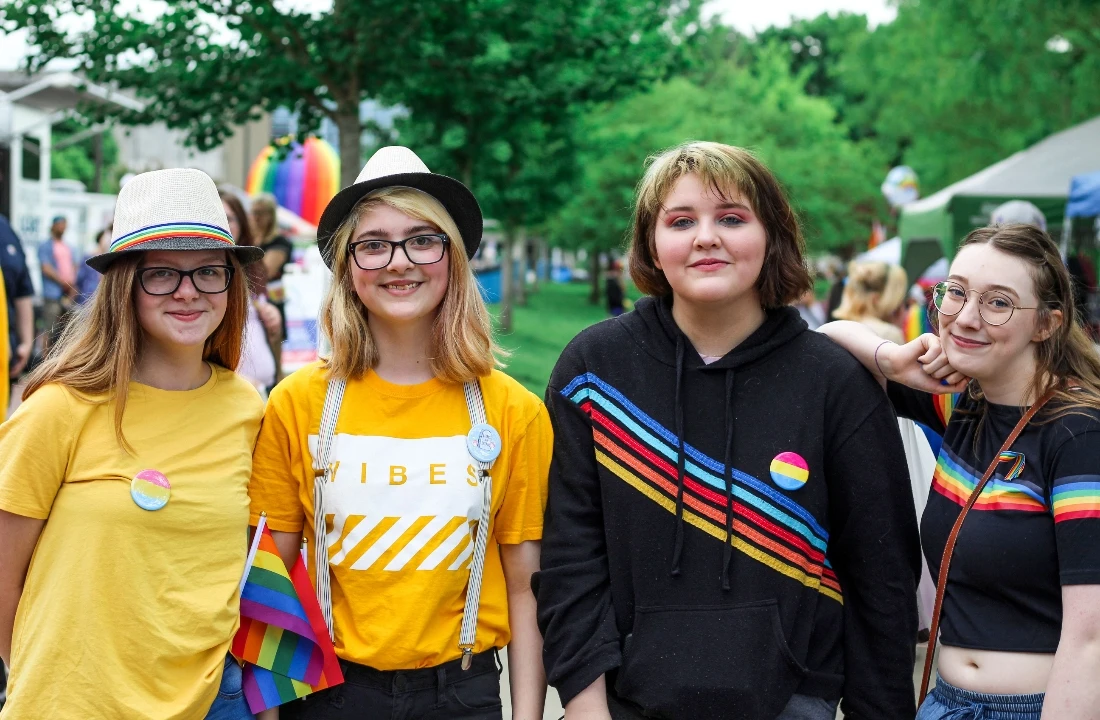 Group of young people wearing rainbow-themed Pride Apparel at an outdoor community event