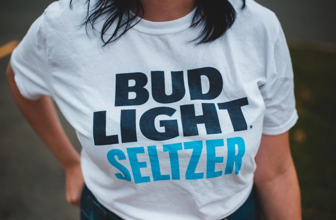 Close-up of a white POD T shirt with large bold typography printed across the front