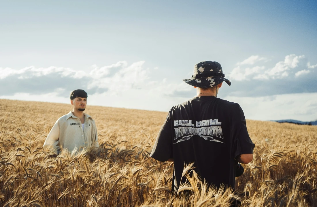 Two people wearing Heavyweight T Shirts in an outdoor field setting with relaxed streetwear styling