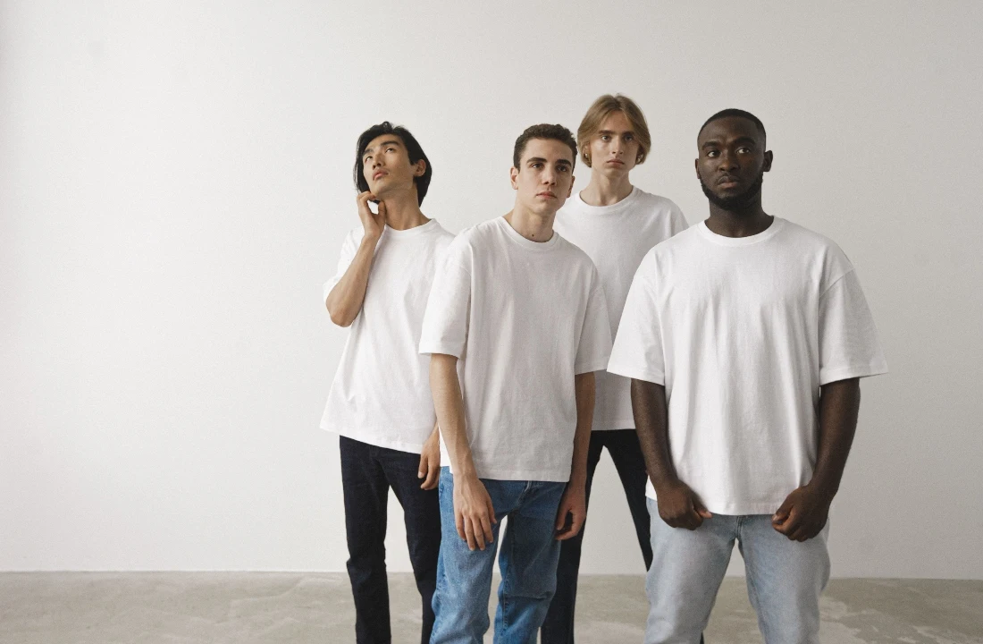 Group of models wearing white Heavyweight T Shirts in a studio setting for fit and silhouette comparison