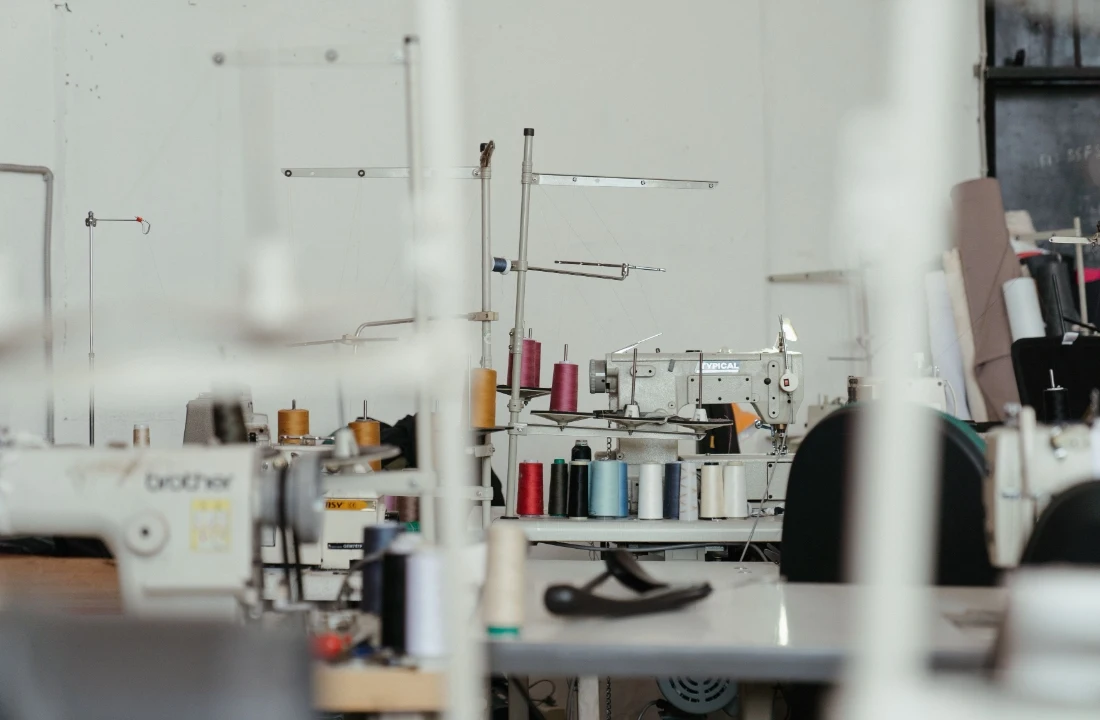 Sewing machines and thread setup inside a workshop for custom apparel production