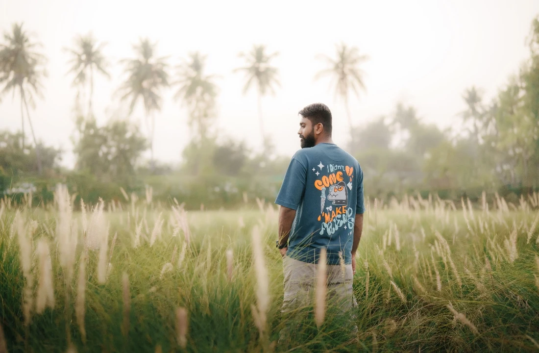 Man wearing a back print graphic T-shirt in an outdoor field for Print on Demand Streetwear promotion