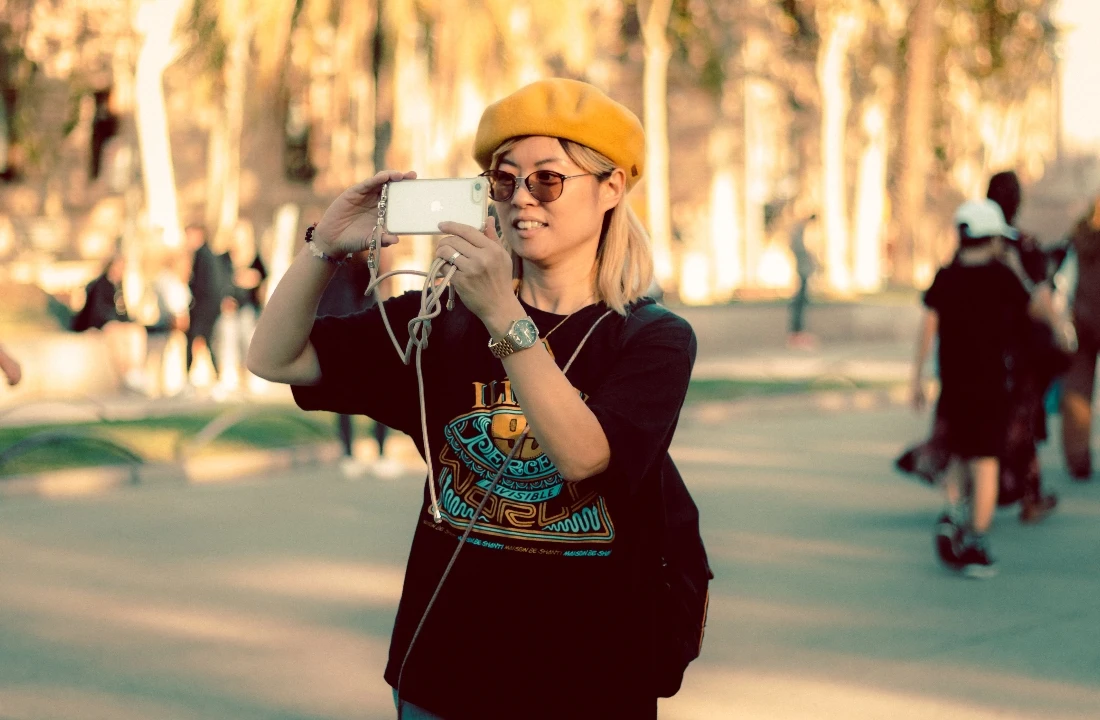 Woman taking a photo while wearing a graphic T-shirt for Print on Demand Streetwear branding