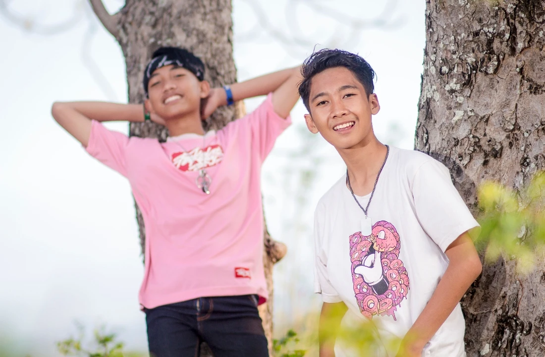 Two young models wearing pink and white graphic T-shirts for a DTF vs DTG printing comparison