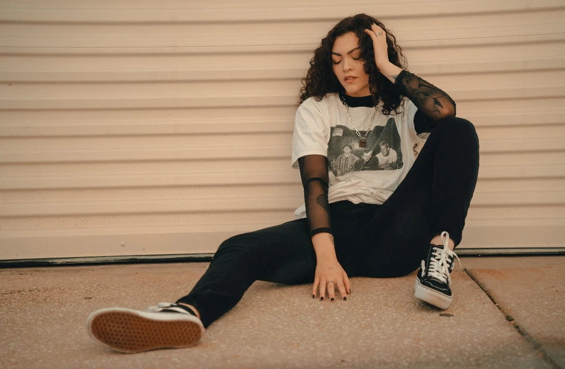 Woman styling a vintage graphic T-shirt layered over a black mesh top for a DTF vs DTG comparison