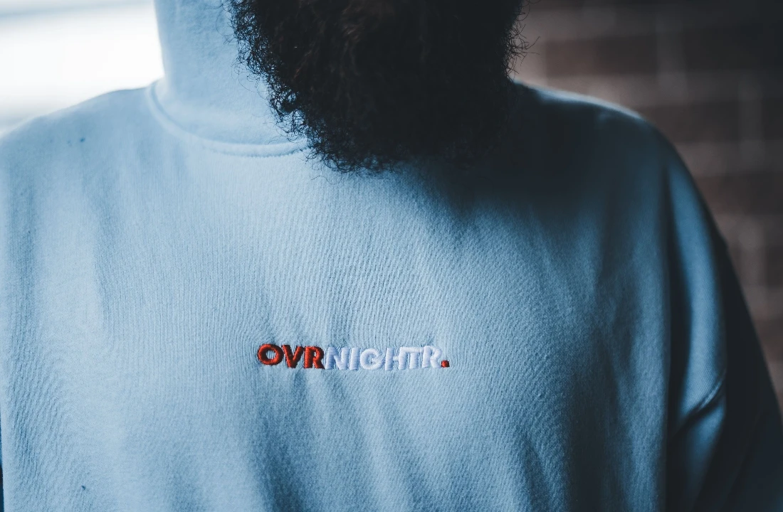 Light blue embroidery hoodie featuring a small two-color embroidered logo at the center chest