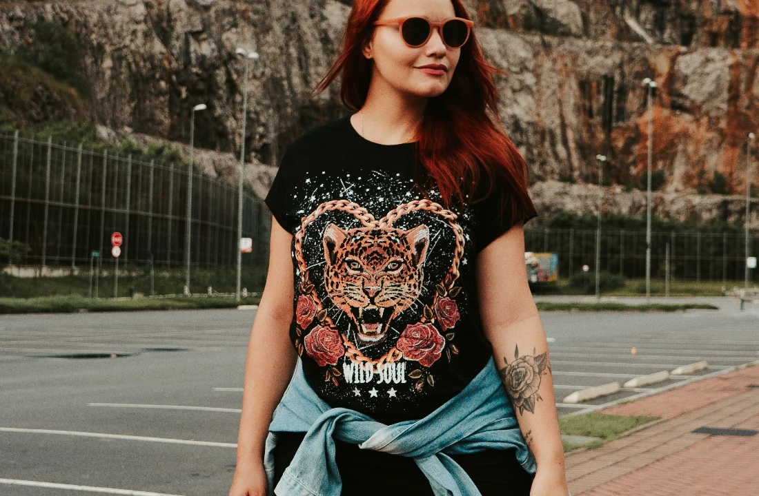 Woman wearing a black T-shirt with a large Jumbo Print leopard, chain and rose design across the front