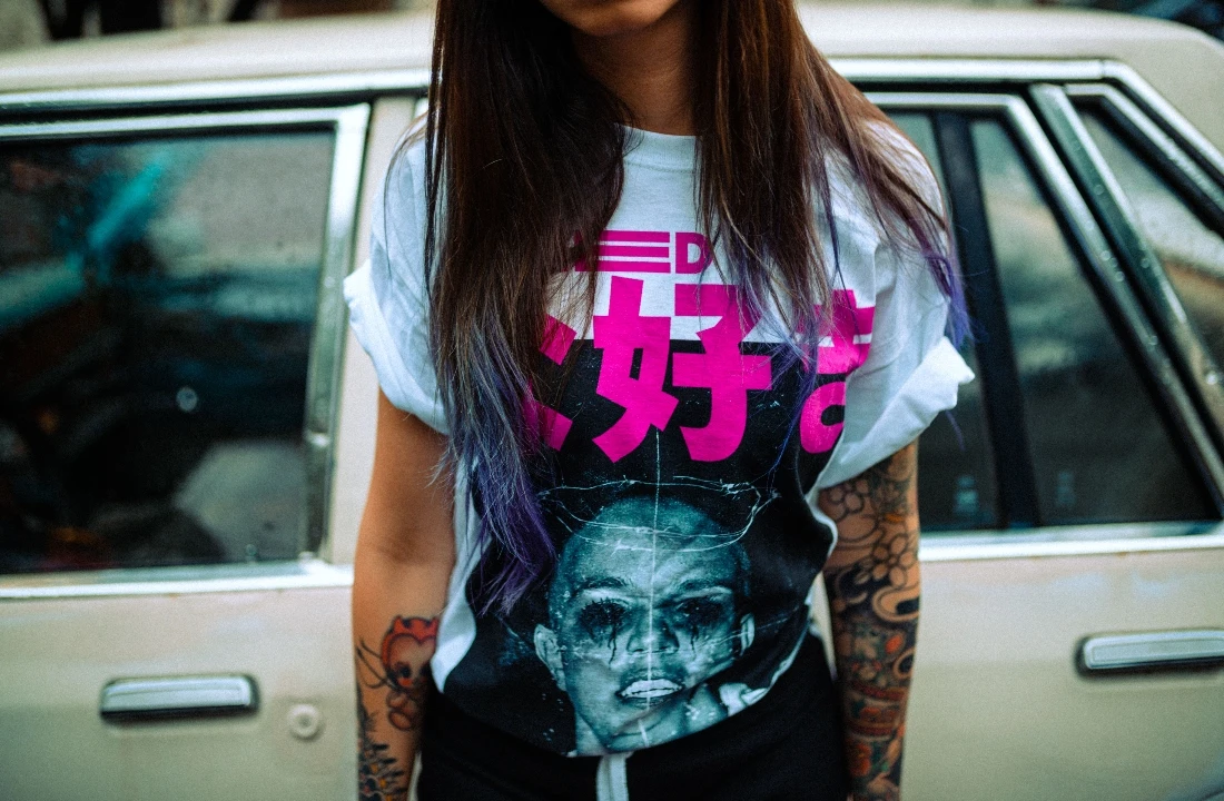 Woman wearing a white streetwear T-shirt with a bold pink and black Jumbo Print portrait graphic