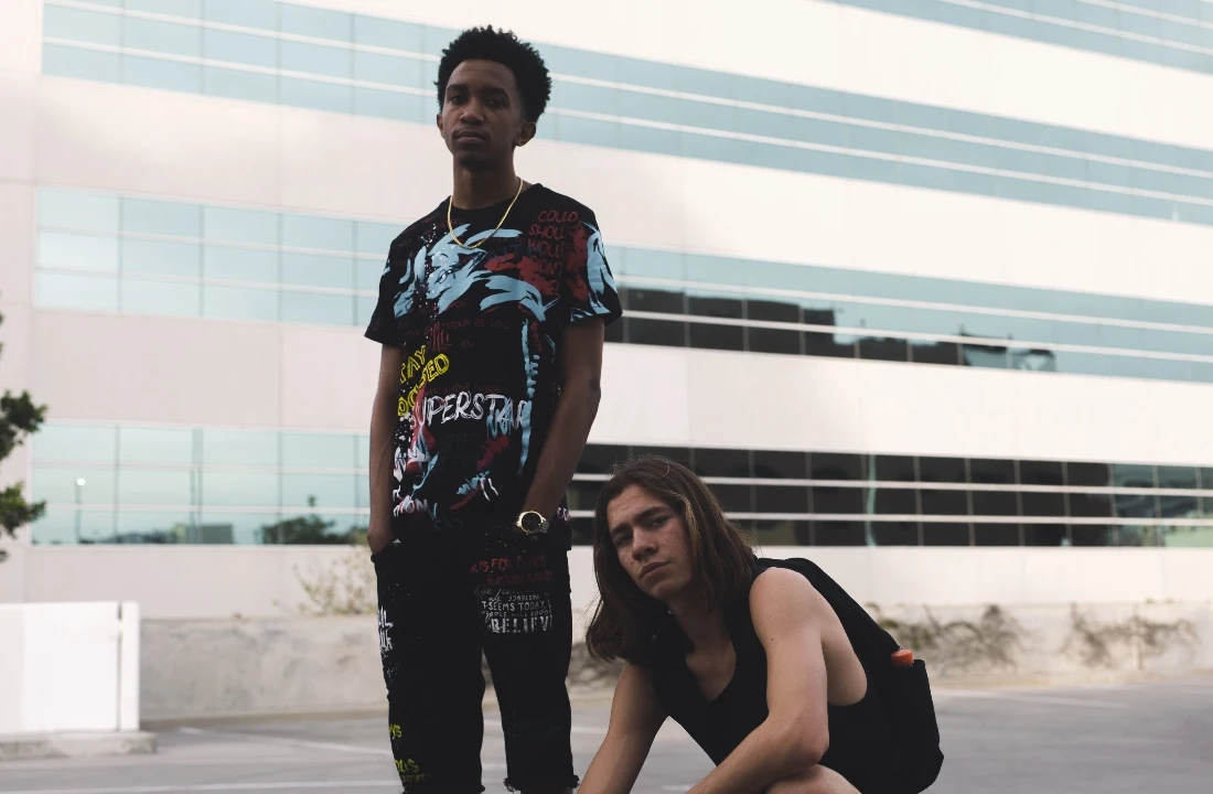 Man wearing a black streetwear T-shirt with a colorful oversized Jumbo Print graphic in an urban setting