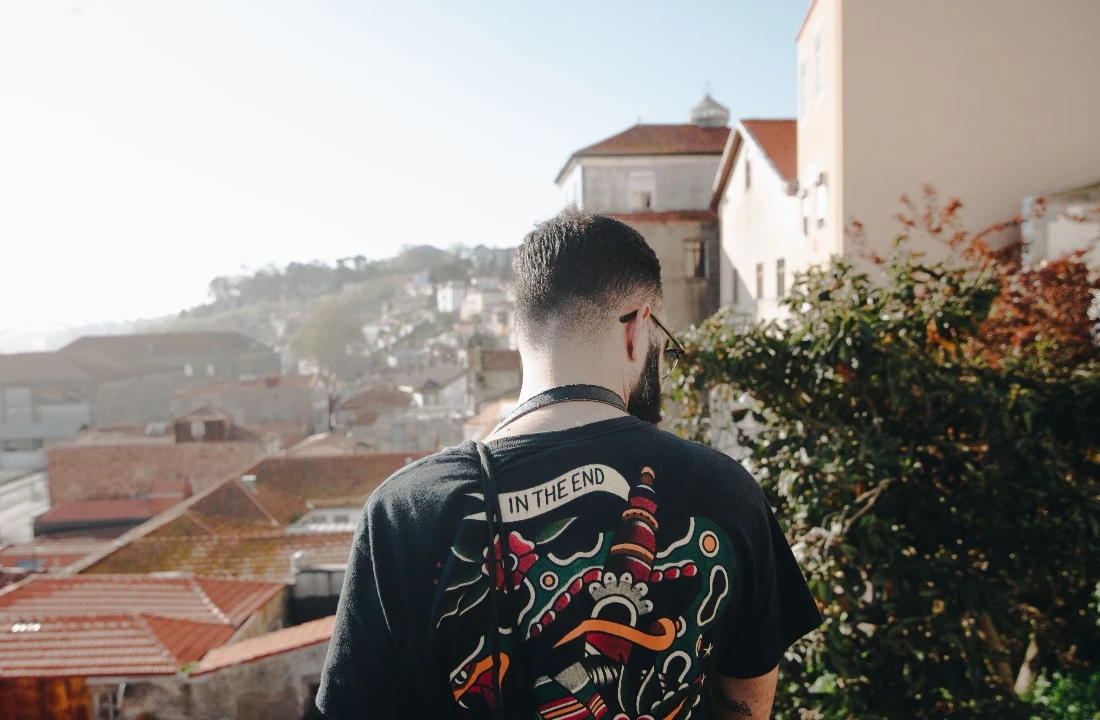 Man wearing a black T-shirt with a large colorful Jumbo Print artwork covering the back
