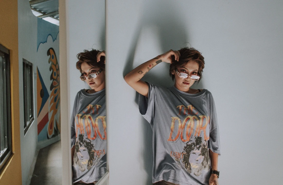 Woman wearing an oversized grey T-shirt with a large vintage-style Jumbo Print graphic across the front