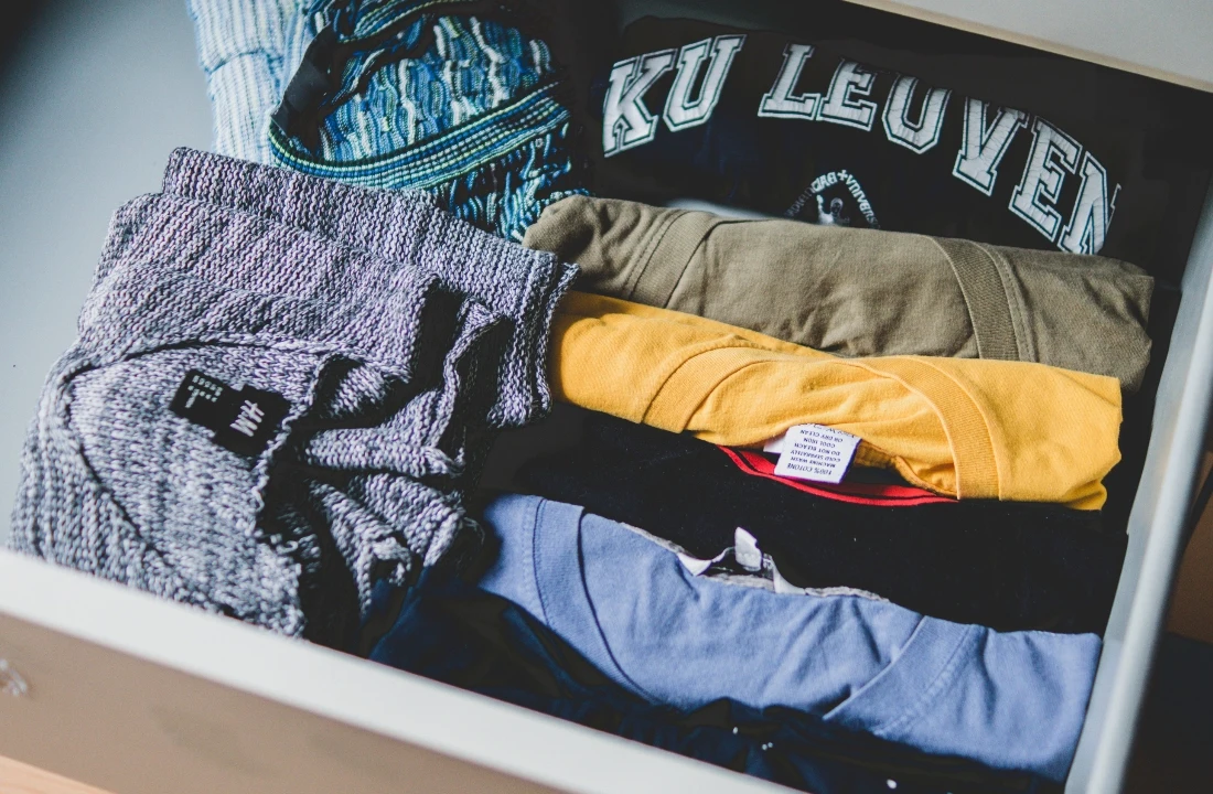 Folded shirts and knitwear arranged inside a box to illustrate organized custom packaging for apparel