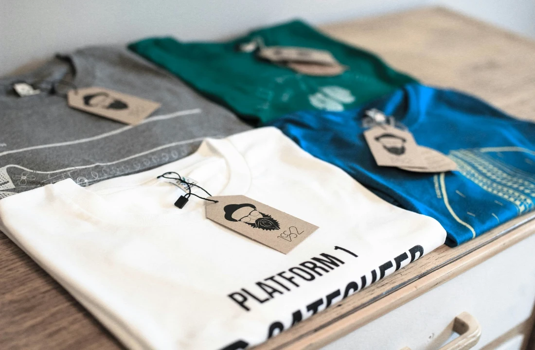 Folded graphic T-shirts displayed with branded hang tags for custom apparel packaging and presentation