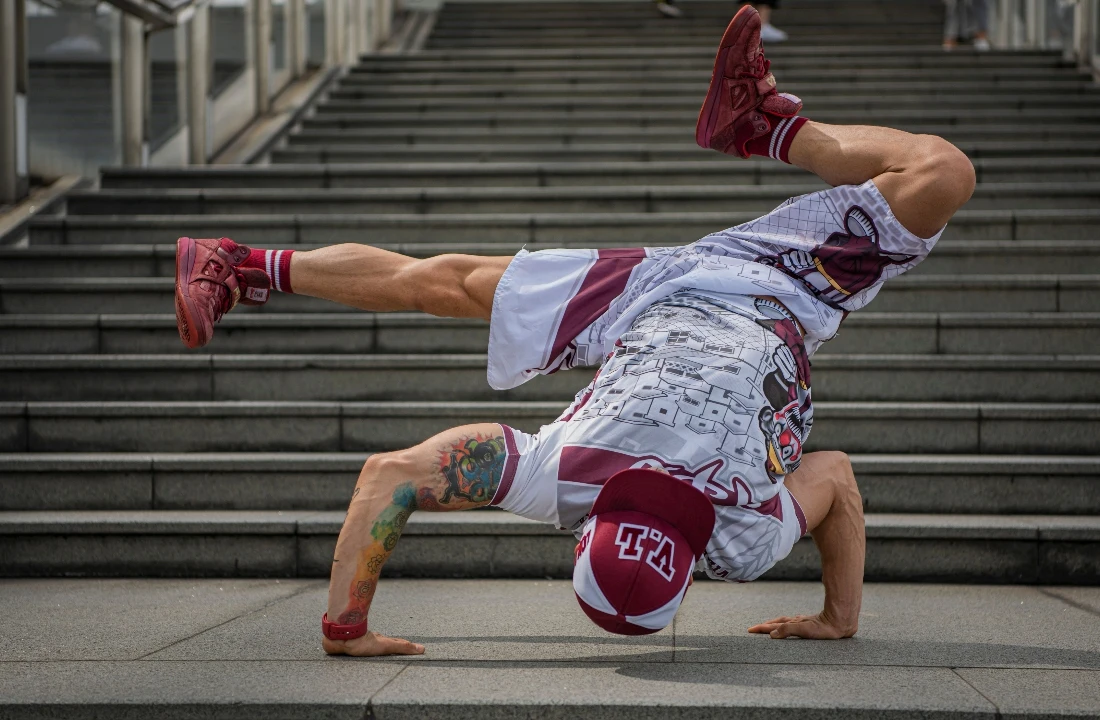 Breakdancer wearing matching graphic Streetwear Shorts and a printed top while performing on outdoor steps