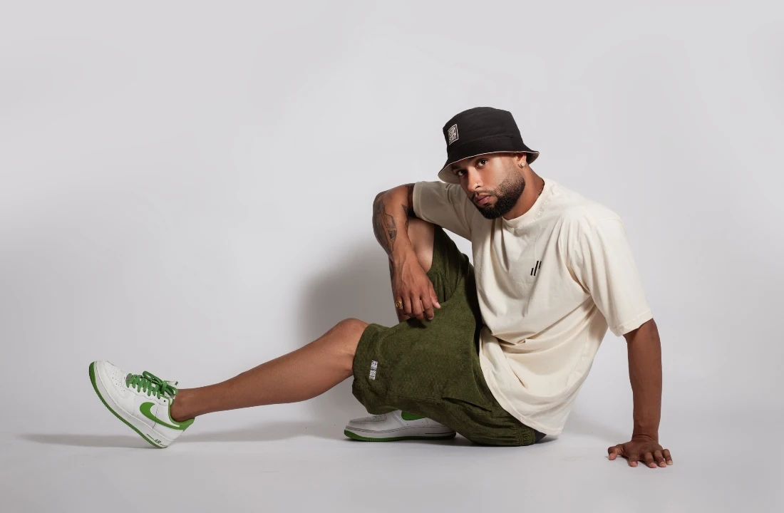 Man styling olive green Streetwear Shorts with an oversized cream T-shirt and bucket hat