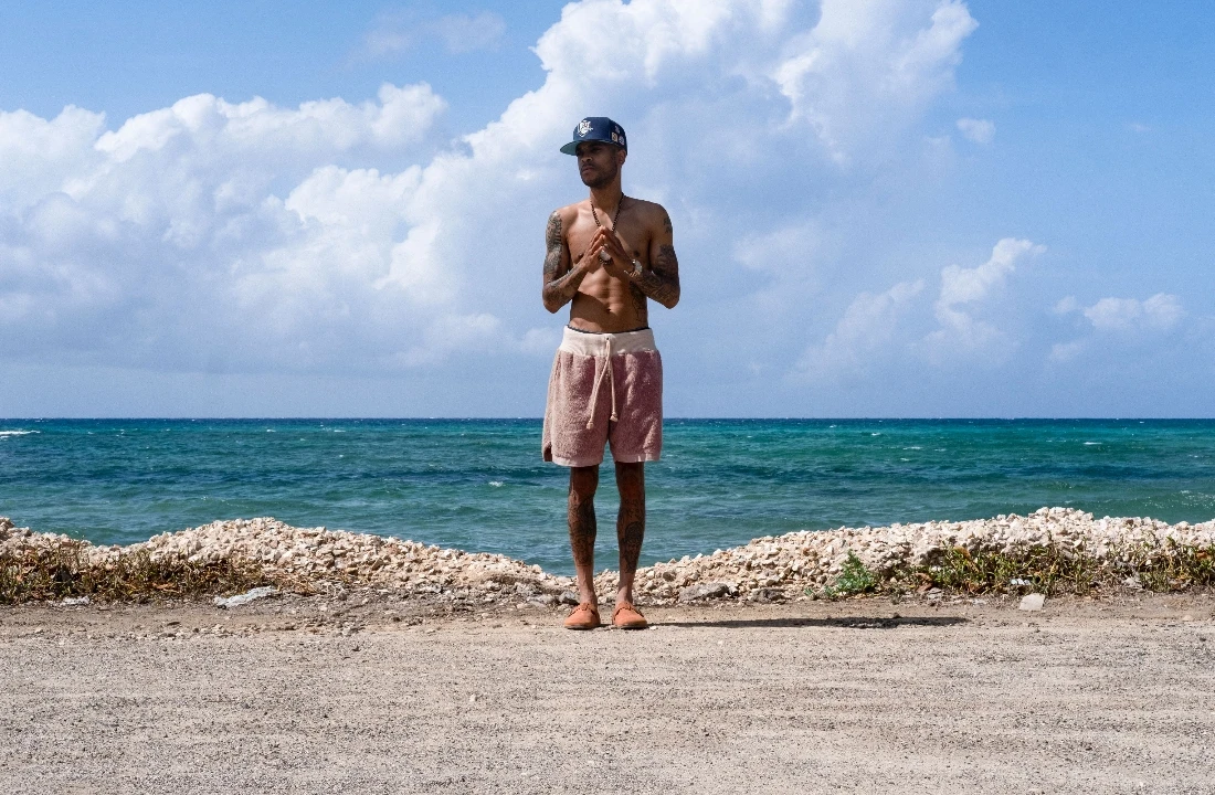 Man wearing textured pink Streetwear Shorts with a drawstring waist beside the ocean