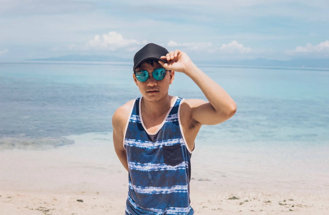 Man wearing a blue striped Custom Tank Top with a contrasting chest pocket at the beach