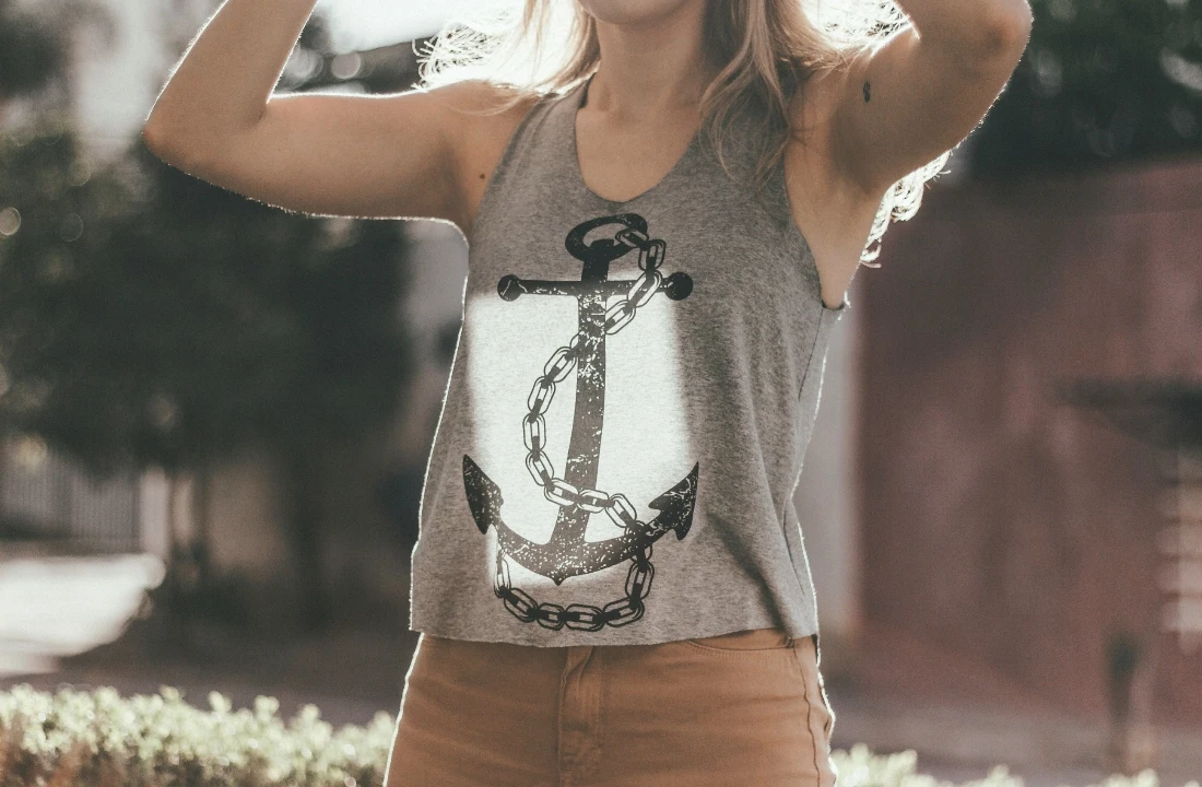 Woman wearing a grey Custom Tank Top featuring a large black anchor and chain graphic on the front