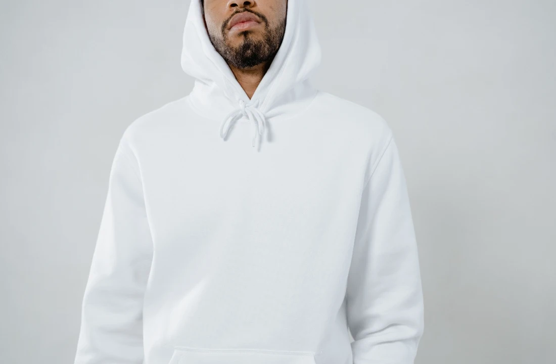 Model wearing a blank white Custom Apparel hoodie with drawstrings and a front kangaroo pocket