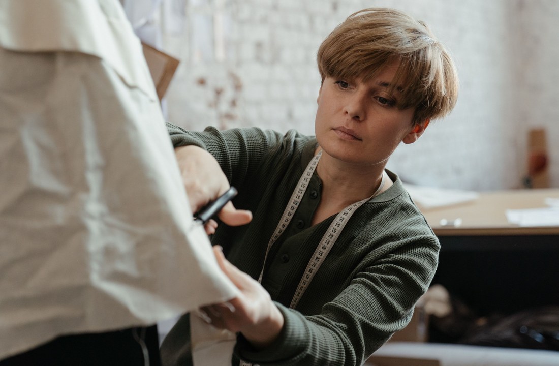 Tailor checking garment fit during hoodie sample quality control