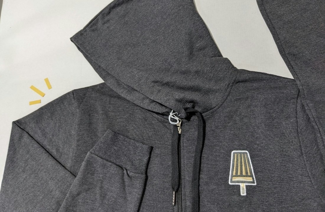 Zip-up hoodie showing chest artwork placement beside the zipper