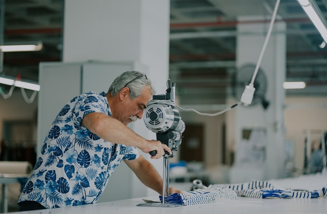 Private label apparel production with fabric cutting at an industrial table
