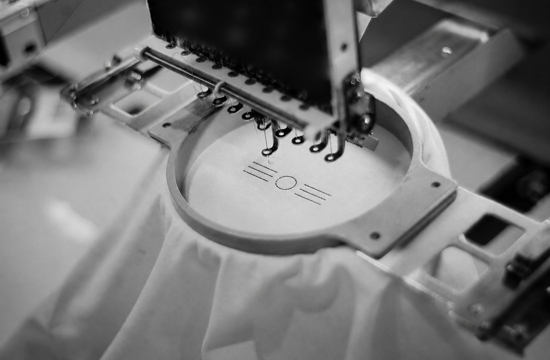 Industrial embroidery process applying a neutral test design for private label apparel