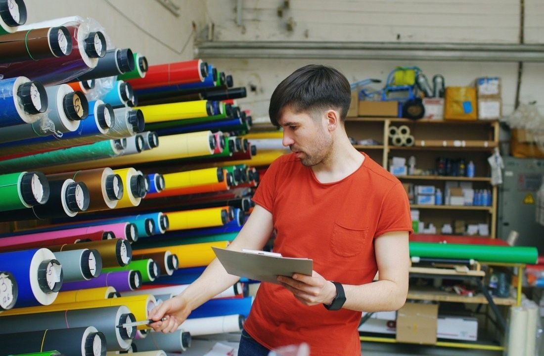 Apparel worker checking materials during clothing manufacturer lead time planning