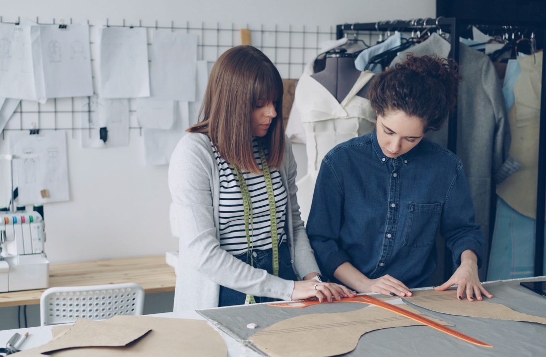 Apparel team reviewing sweatshirt sample measurements before a fall production run