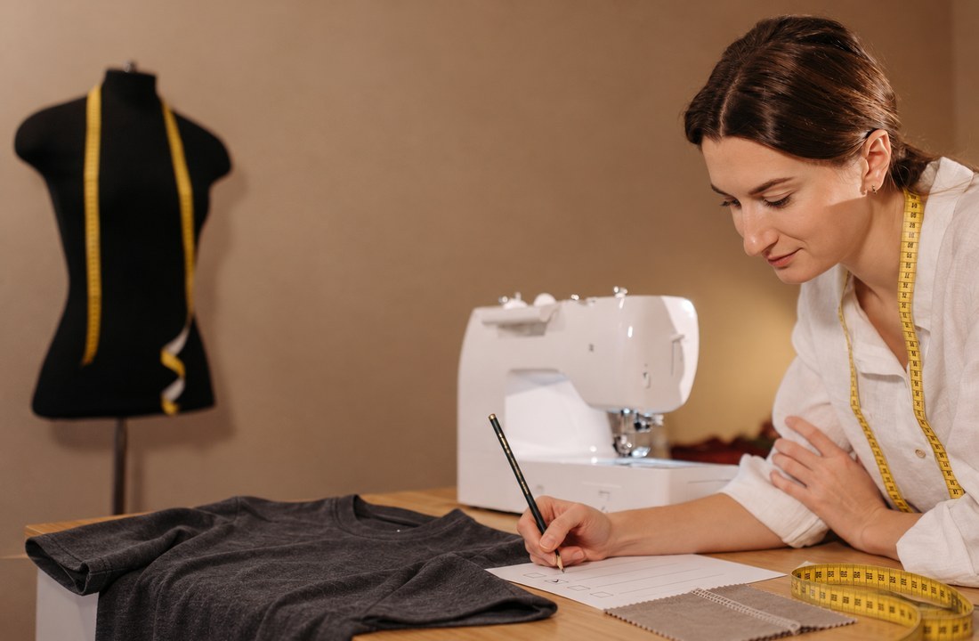 Seamstress checking a plain T-shirt sample with tape measure and QC notes