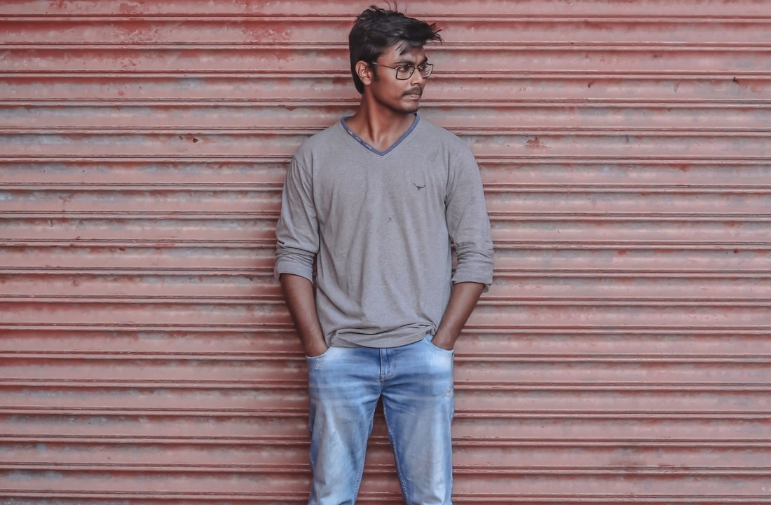 Gray long-sleeve shirt worn against a brick backdrop