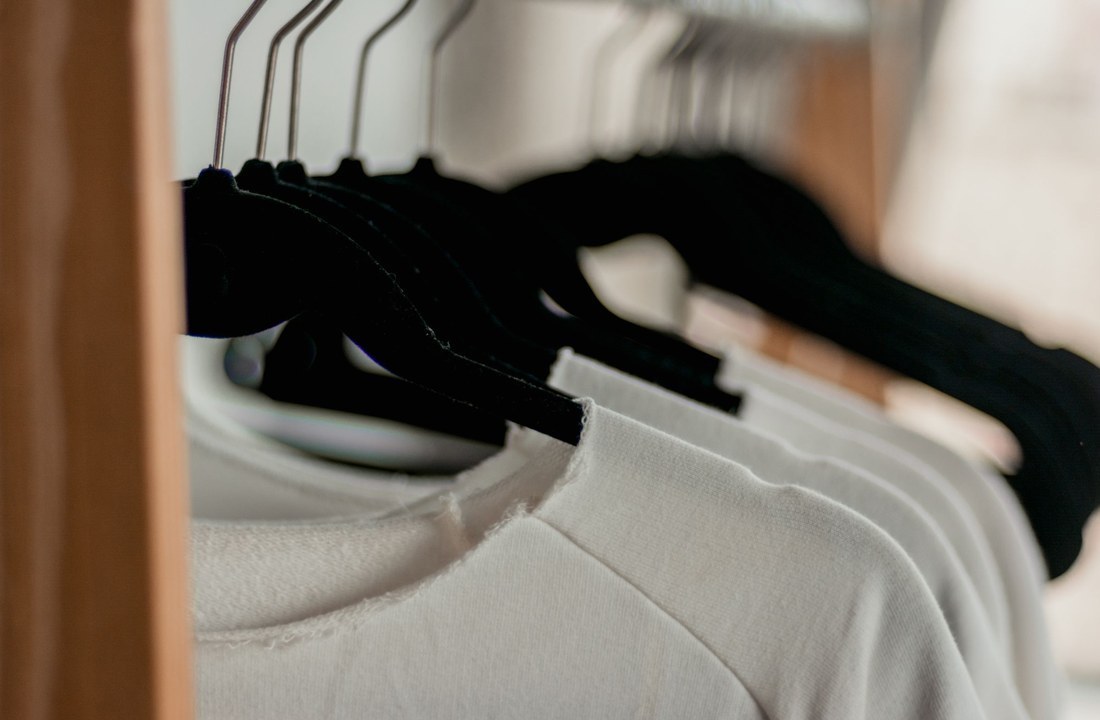 Close view of T-shirt collars and fabric on hangers