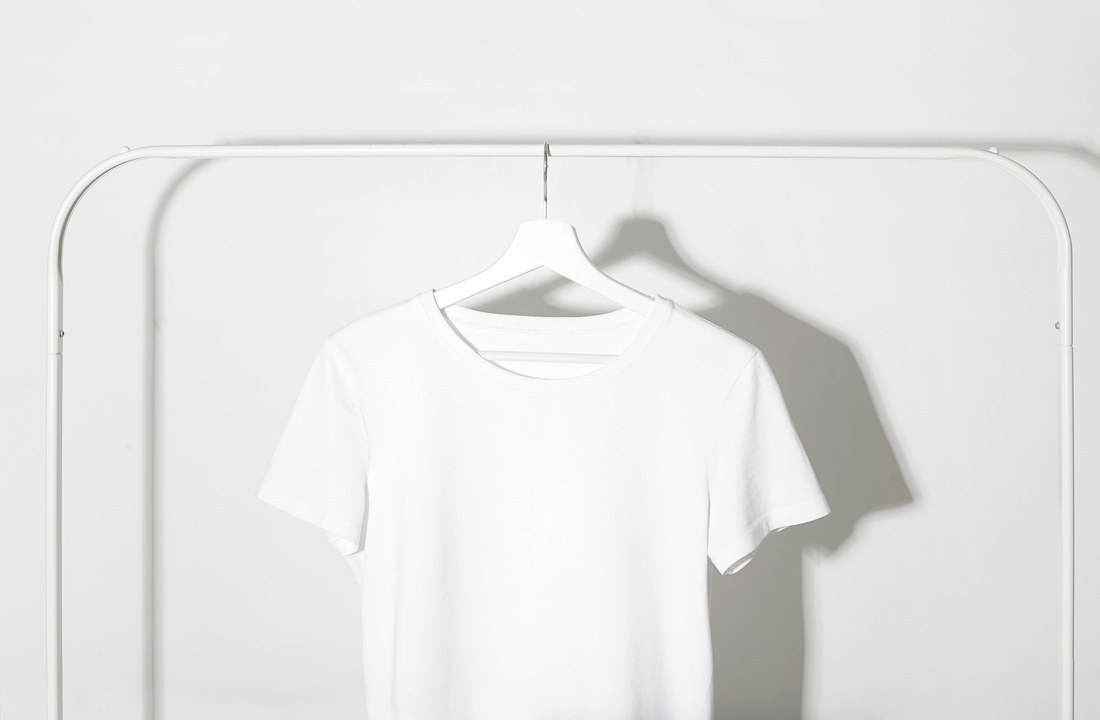Plain white T-shirt hanging on a studio rack